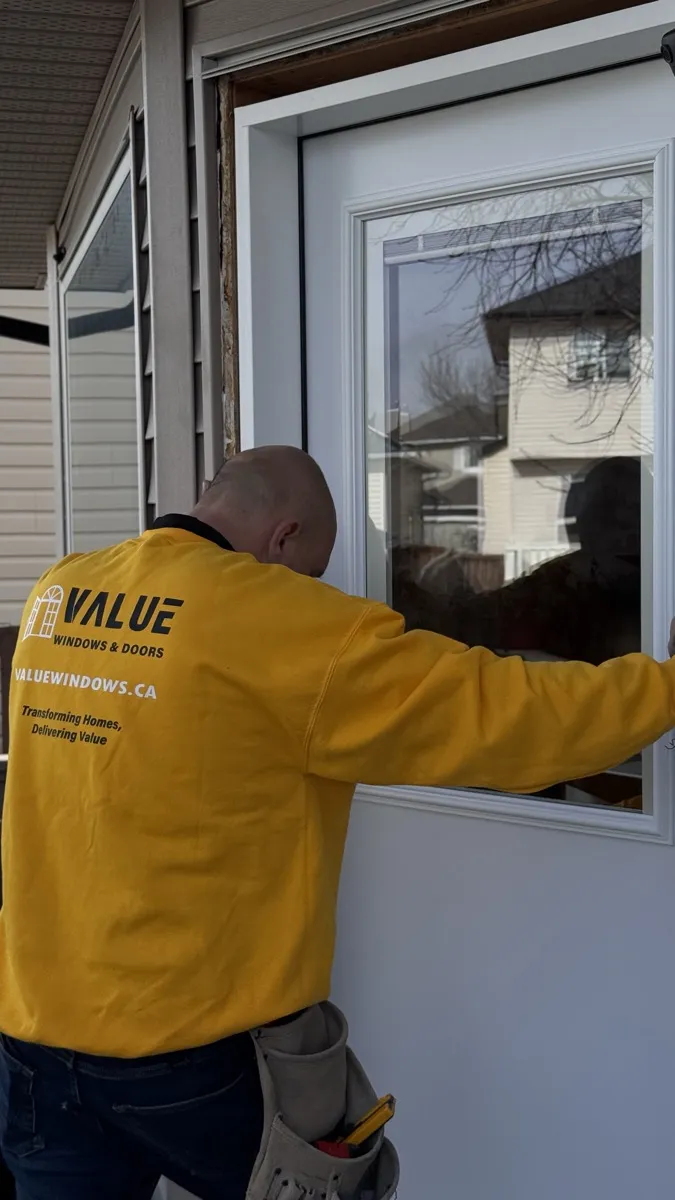 Value Windows installer inspecting glass panes on a newly installed window in Edmonton